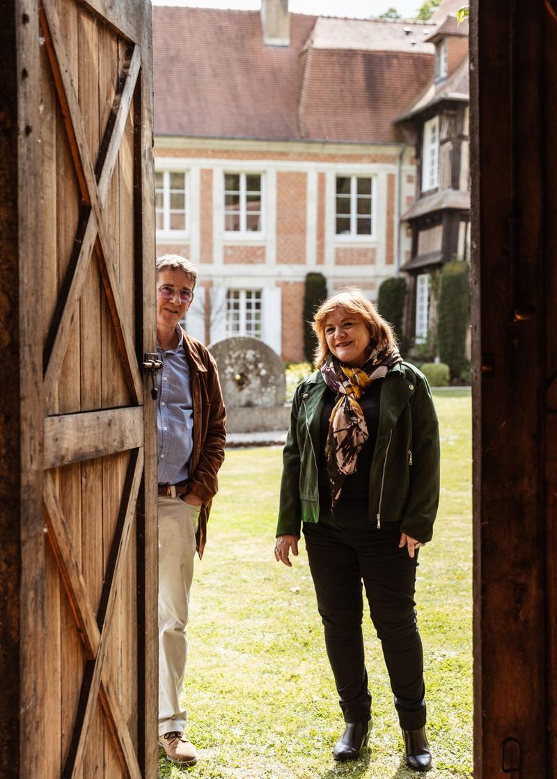 Cécile Roudaut and Philippe Etignard seen through door of barrel cellar at Chateau de Breuil